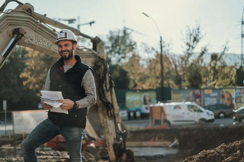 Lehrstellen in Leibnitz Partl Bau Mitarbeiter steht mit einem Plan in der Hand auf einer Baustelle in Leibnitz