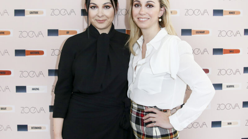 Zoe und Barbara Boukoi, die Gründerinnen von ZOEVA posieren vor einer Werbetafel